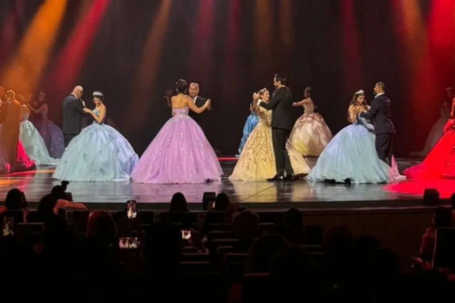 Quinceañeras bailan con sus padres bajo luces de colores durante la gala