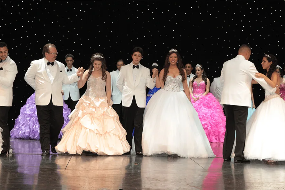Quinceañeras dancing with their families at the gala