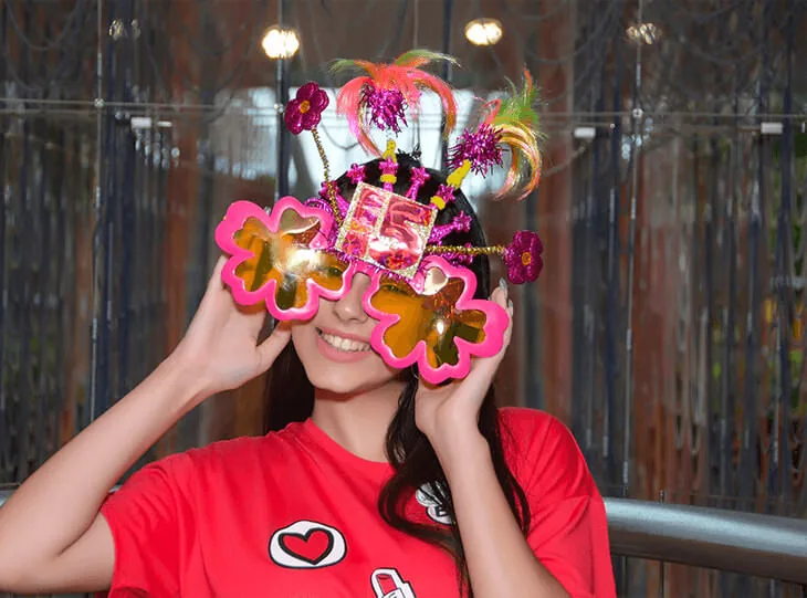 Quinceañera wearing festive glasses at the welcome party